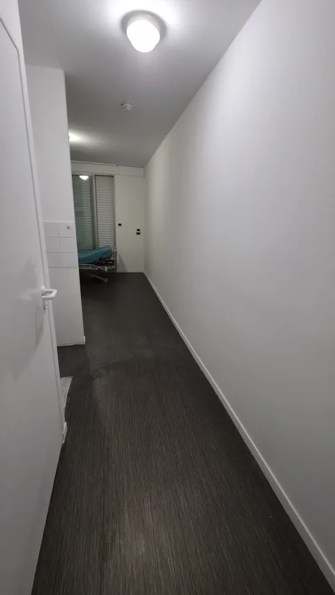 Circulation de la chambre d’EHPAD remise au propre avec finitions blanches régulières