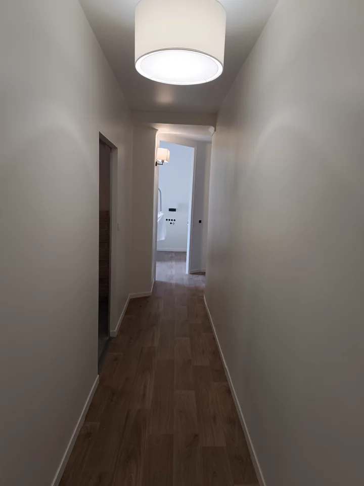 Couloir rénové avec murs blancs et finition régulière