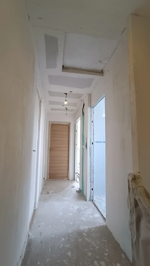 Couloir avec plafonds et murs en cours de reprise avant mise en peinture